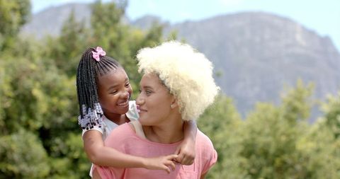 Playful Outdoor Bonding Between Smiling Mother and Daughter