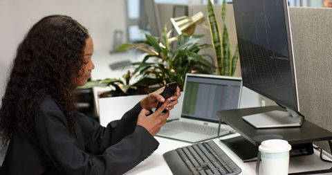 Young professional using smartphone at modern office workspace