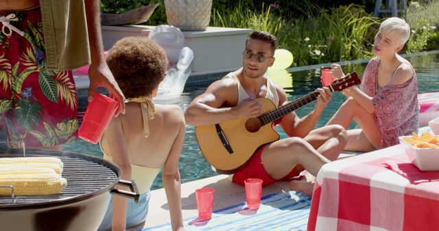 A group of friends relaxing by a pool. One person plays guitar, creating a lively atmosphere while others engage in conversation. A barbecue nearby indicates a cookout, with corn grilling on the barbecue. Ideal for depicting summer parties, outdoor gatherings, and social events promoting leisure and enjoyment.
