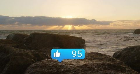 Sunset Over Ocean with Digital Thumbs Up Notification