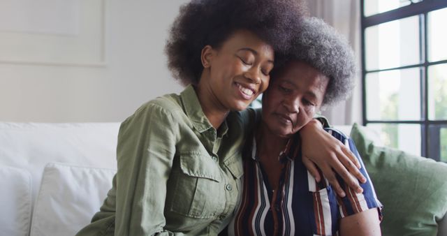 Happy african american adult daughter and emotional senior mother hugging at home, slow motion - Download Free Stock Photos Pikwizard.com