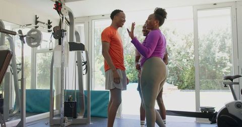 Personal trainer assisting young couple in reaching fitness goals