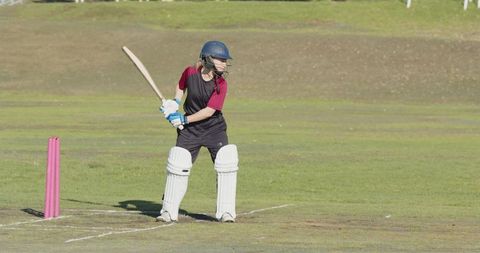 Female cricket player ready to bat on field