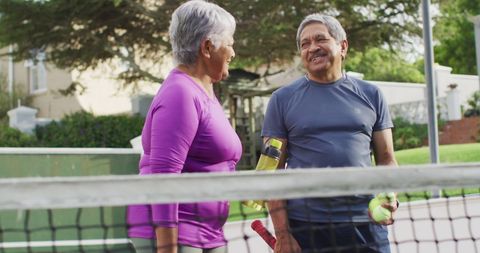 Active senior couple enjoying tennis outdoors together