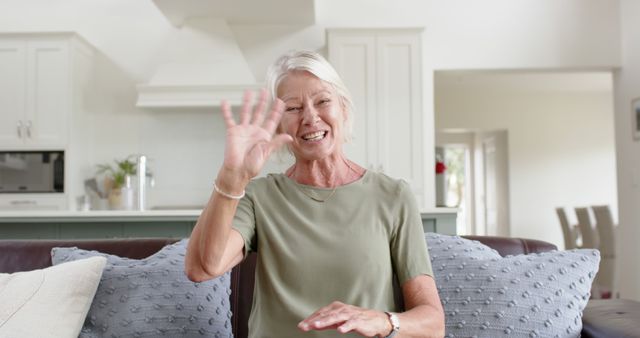 Smiling Elderly Woman Waving in Modern Living Room - Download Free Stock Images Pikwizard.com