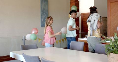 Friends Celebrating Home Gathering with Balloons and Decorations
