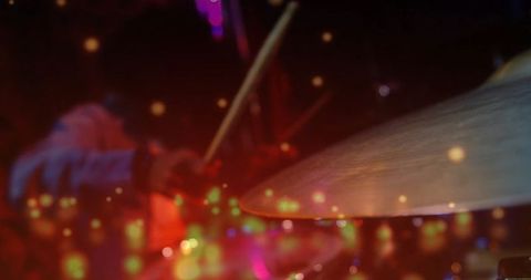 Energetic drummer perform under colorful stage lights