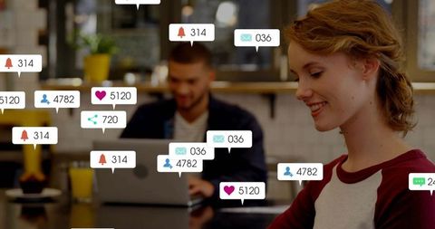 Smiling young professionals collaborating in cafe with social media engagement bubbles