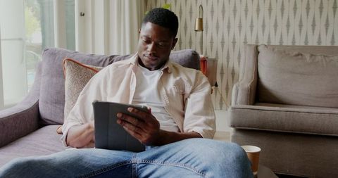 African American Man Relaxing with Tablet in Modern Living Room