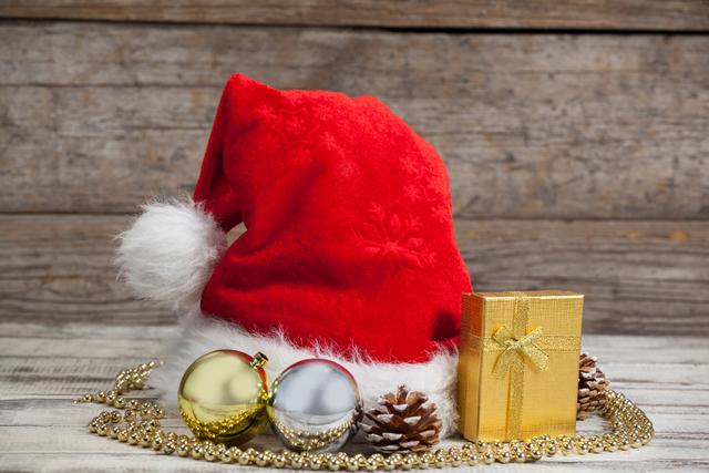 Christmas decoration, gift and santa hat kept on wooden table during Christmas time