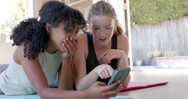 Two Young Women Laughing and Bonding While Looking at Smartphone - Download Free Stock Images Pikwizard.com