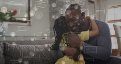 Father and daughter sharing warm hug on living room sofa with digital message overlay
