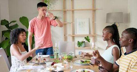 Friends Enjoying Dinner with a Toast in Relaxed Home Setting