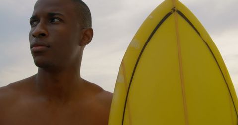 Confident Surfer with Yellow Board on Beach