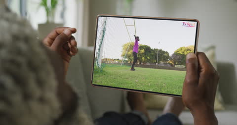 Man Streaming Soccer Match on Tablet at Home