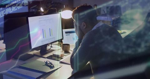Businessman Frustrated by Data Analytics on Workplace Monitors