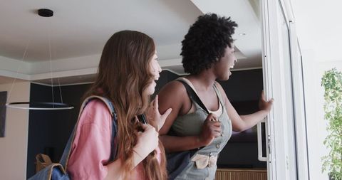 Diverse Friends Enter Hotel Room Admiring Scenic View