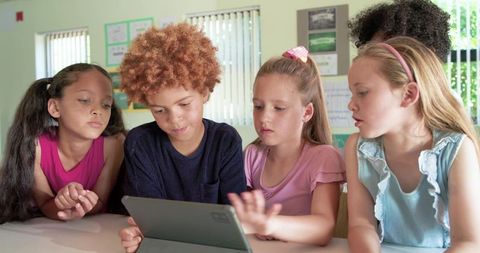 Elementary Students Collaborating on Tablet for Interactive Classroom Learning