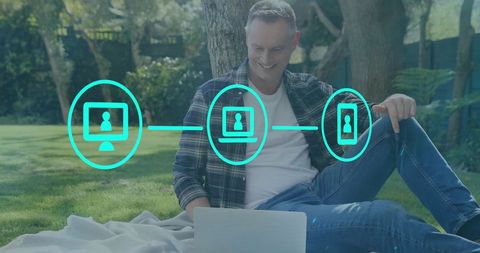Caucasian man relaxing in park with digital network concept overlay