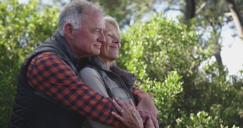 Senior Couple Embracing in Sunlit Forest