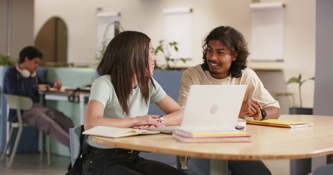 African American Students Collaborating in Campus Study Lounge with Laptop and Notebooks