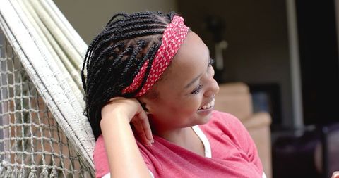 Young Woman Relaxing in Hammock Smiling Outdoors
