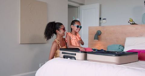 Mother and Daughter Packing Suitcase for Vacation