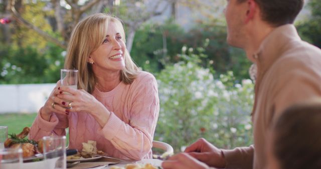Image of happy caucasian senior mother and adult son talking at outdoor family dinner table - Download Free Stock Photos Pikwizard.com