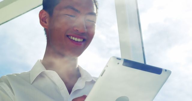 Young Professional Smiling While Using Tablet Against Clear Sky - Download Free Stock Images Pikwizard.com