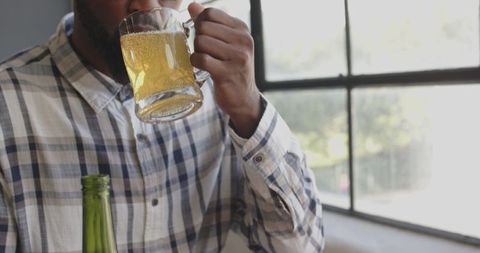 Man Enjoying Beer Mug Near Window in Casual Atmosphere - Download Free Stock Images Pikwizard.com