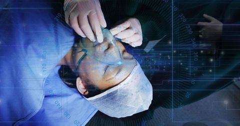 Clinician placing anesthesia mask over patient with digital monitoring overlays