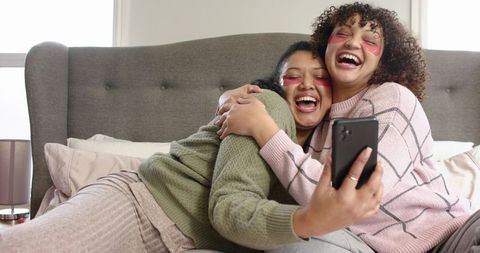Cozy Girls Night Hugging on Bed Wearing Under-Eye Patches While Taking Selfie