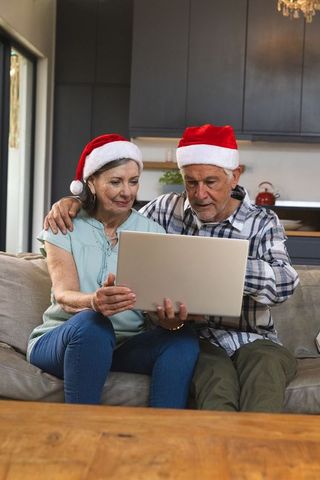 Senior Couple Enjoying Festive Season with Laptop Technology at Home