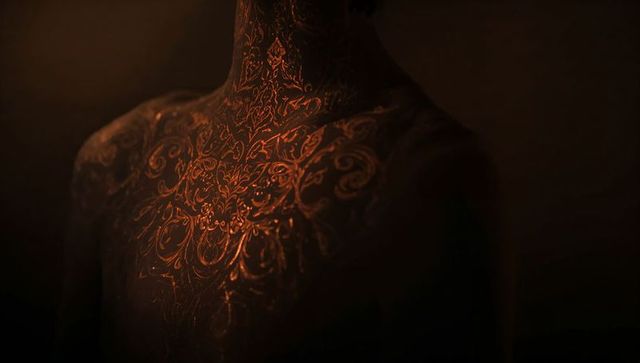 Elegant torso with gold filigree patterns glowing in low light