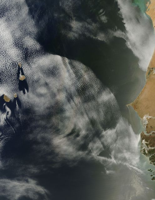 On April 23, 2013 NASA’s Terra satellite passed off the coast of West Africa, allowing the Moderate Resolution Imaging Spectroradiometer (MODIS) flying aboard to capture a curious phenomenon over the cloud deck below. The rainbow-like discoloration that can be seen streaking across the bank of marine cumulus clouds near the center of this image is known as a “glory”.  A glory is caused by the scattering of sunlight by a cloud made of water droplets that are all roughly the same size, and is only produced when the light is just right. In order for a glory to be viewed, the observer’s anti-solar point must fall on the cloud deck below. In this case the observer is the Terra satellite, and the anti-solar point is where the sun is directly behind you – 180° from the MODIS line of sight. Water and ice particles in the cloud bend the light, breaking it into all its wavelengths, and the result is colorful flare, which may contain all of the colors of the rainbow.  Credit: NASA/GSFC/Jeff Schmaltz/MODIS Land Rapid Response Team  <b><a href="http://www.nasa.gov/audience/formedia/features/MP_Photo_Guidelines.html" rel="nofollow">NASA image use policy.</a></b>  <b><a href="http://www.nasa.gov/centers/goddard/home/index.html" rel="nofollow">NASA Goddard Space Flight Center</a></b> enables NASA’s mission through four scientific endeavors: Earth Science, Heliophysics, Solar System Exploration, and Astrophysics. Goddard plays a leading role in NASA’s accomplishments by contributing compelling scientific knowledge to advance the Agency’s mission.  <b>Follow us on <a href="http://twitter.com/NASA_GoddardPix" rel="nofollow">Twitter</a></b>  <b>Like us on <a href="http://www.facebook.com/pages/Greenbelt-MD/NASA-Goddard/395013845897?ref=tsd" rel="nofollow">Facebook</a></b>  <b>Find us on <a href="http://instagram.com/nasagoddard?vm=grid" rel="nofollow">Instagram</a></b>
