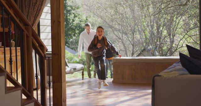 Excited Boy Running into Home with Father in Background - Download Free Stock Images Pikwizard.com