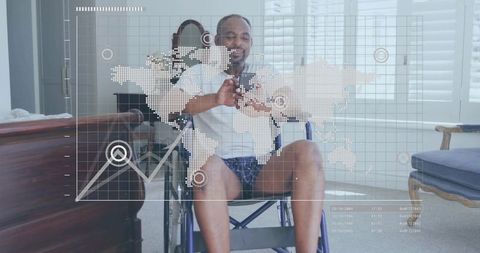 Smiling mature man in wheelchair holding smartphone with world map and data graph overlay