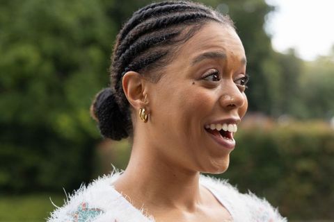 African american woman reacting with delight wearing fluffy sweater and gold hoops in park