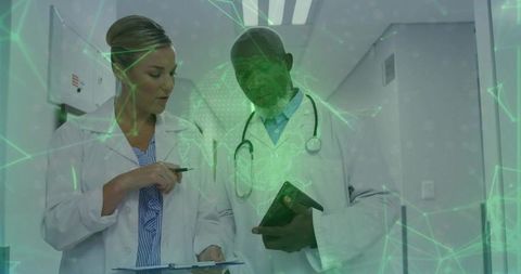 Medical team reviewing notes with green network overlay, collaborative care planning hub