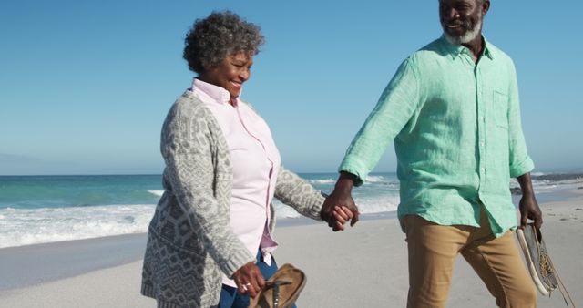 Happy african american senior couple holding hands on beach by seaside with copy space - Download Free Stock Photos Pikwizard.com