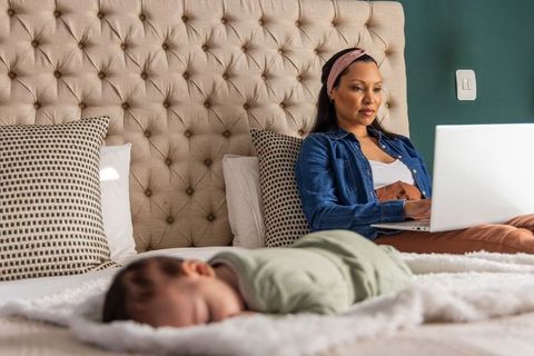 Working from bed with sleeping baby, balancing remote work and newborn care