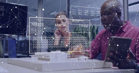 Designers collaborating over scale model with augmented reality overlays in modern office