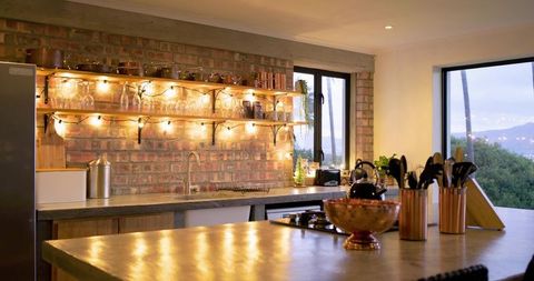 Warm rustic modern kitchen island with polished concrete countertop and exposed brick