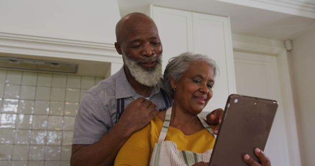 African american senior couple having a image call on digital tablet in the kitchen at home. retirement senior couple lifestyle living concept