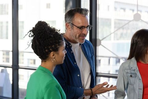 Diverse team collaborating in bright modern office near large windows