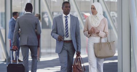 Diverse Professionals Walking Through Modern Office Hallway Discussing Business