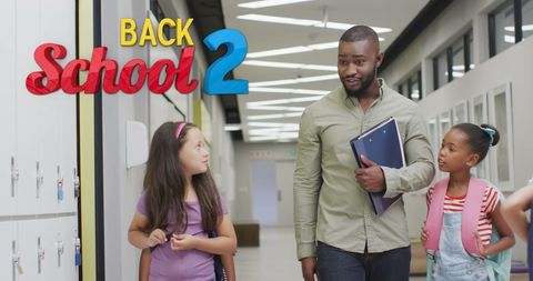 Diverse Teacher Engaging with Students in School Corridor