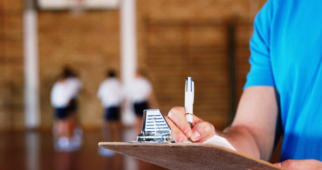 Coach Writing Notes on Clipboard During Basketball Practice - Download Free Stock Images Pikwizard.com