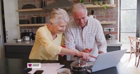 Senior Couple Collaborating on Laptop at Home Kitchen