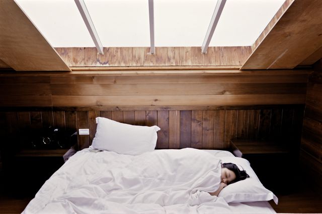 Person Sleeping in Wooden Cabin Bedroom with Skylight Window - Download Free Stock Photos Pikwizard.com